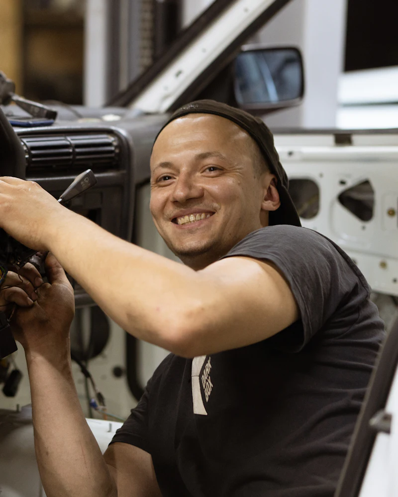 Mechanic smiling while working on a car